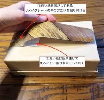 白い紙を少し剥がしたリメイクシートを貼りたい場所に貼る
